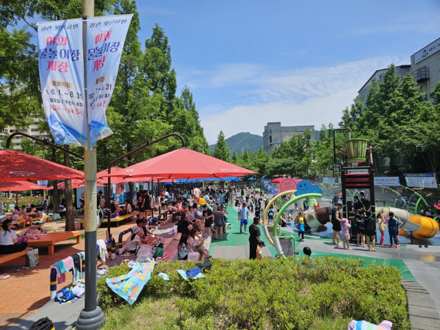 기장군 정관 윗골공원 물놀이장. 물놀이장 주변에 돗자리를 편 어른들은 때론 아이들과 물놀이를 즐기고 때론 챙겨온 음식을 먹으며 무더위를 피한다. 기장군청 제공