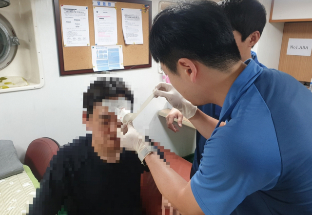 19일 오전 3시 10분께 통영시 욕지도 남방 14해리에 있던 낚시어선에서 낚싯바늘이 낚시객 눈꺼풀을 꿰는 사고가 발생했다. 통영해양경찰서 구조대가 원격응급의료시스템을 통해 응급처치를 하고 있다. 통영해양경찰서 제공