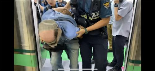 19일 서울 지하철 2호선 열차 안에서 열쇠고리에 붙은 쇠붙이로 승객들을 공격하며 난동을 부린 남성이 경찰에 체포되고 있다. 연합뉴스
