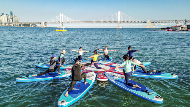 수영구 광안리해수욕장에서 '크레이지서퍼스'가 진행한 SUP 요가. 부산시 제공