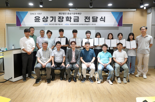 정진웅(자연과학대학장, 앞줄 왼쪽에서 세 번째) 이사장 등 (재)윤상기장학재단 임원들과 장학생들이 기념촬영을 하고 있다