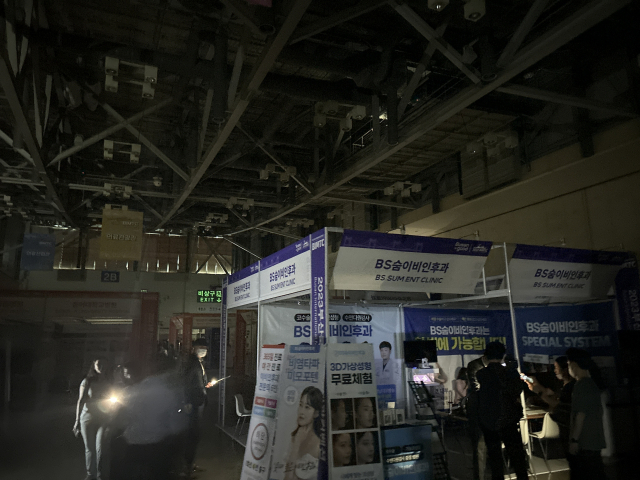 벡스코가 지역 마이스 업계 육성과 상생 의무를 외면하고 안정적인 수익사업에만 골몰한다는 비판의 목소리가 높다. 부산 해운대구 벡스코 전경(위)과 지난 1일 정전으로 불이 꺼진 벡스코의 한 전시관 모습. 부산일보DB·독자 제공