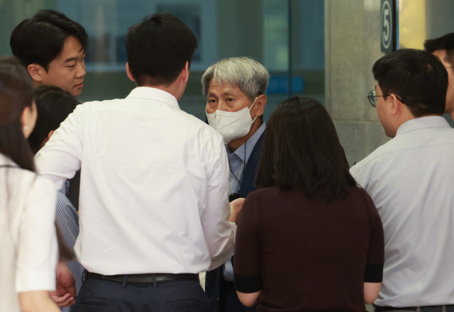 신학림(가운데 마스크 쓴 사람) 전 언론노조 위원장이 7일 오전 서울 서초구 서울중앙지방검찰청에서 취재진의 질문을 받고 있다. 연합뉴스