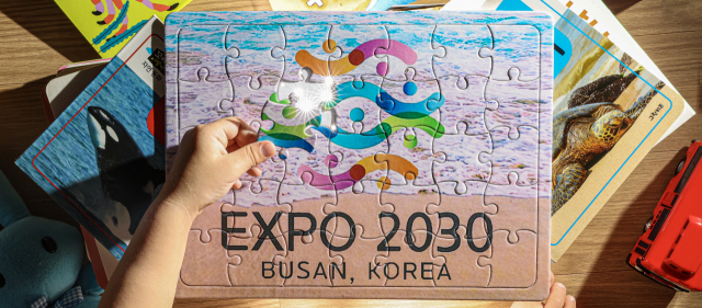 지방소멸 위기를 극복할 대안으로 부산이 제시하고 대한민국 전체가 호응한 도전 과제가 2030세계박람회 유치다. 최종 개최지 결정까지 남은 80여 일, 국민 모두가 하나가 돼 뛰길 소망한다. 결코 쉬운 과제는 아니지만 미래를 위해 꼭 풀어야 할 숙제다. 창간 77주년을 맞아 <부산일보>가 2030엑스포 부산 유치의 마지막 퍼즐이 끝내 맞춰지길 기원하며 제작한 엑스포 퍼즐의 마지막 조각을 한 아이가 완성시키고 있다. 김종진 기자 kjj1761@
