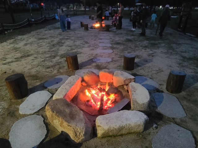 황산공원 불멍존(미니 캠프파이어존)에는 돌화로와 통나무 의자, 땔감 등이 모두 준비돼 있다. 공원 안전 관리요원 2명이 불멍을 할 수 있도록 불을 피워 주고 뒷정리도 해 준다.