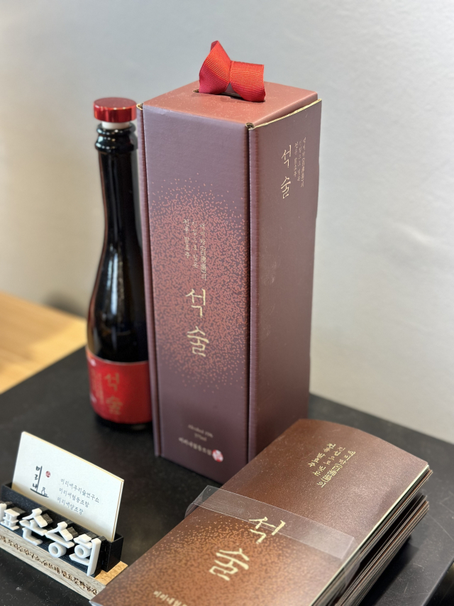 미리내협동조합 입구에 놓인 석술. 검은 병과 붉은 라벨이 눈에 띈다.