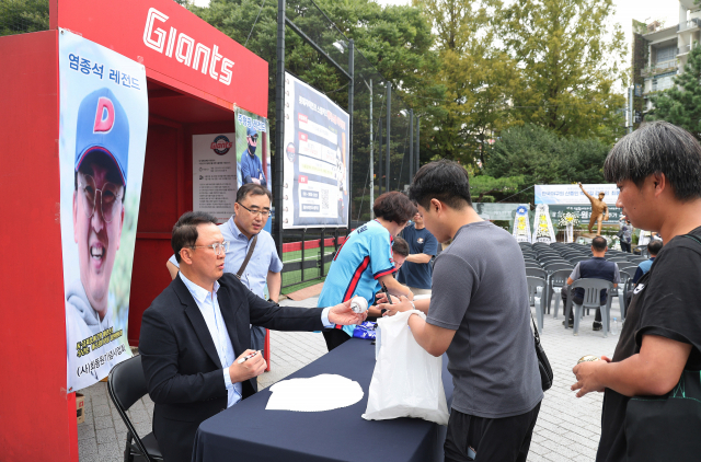 12일 오후 부산 사직야구장 최동원 동상 앞에서 열린 ‘불멸의 무쇠팔 고 최동원 감독 12주기 추모행사’에서 롯데 자이언츠 레전드인 염종석과 주형광이 팬 사인회를 갖고 있다. 정종회 기자 jjh@