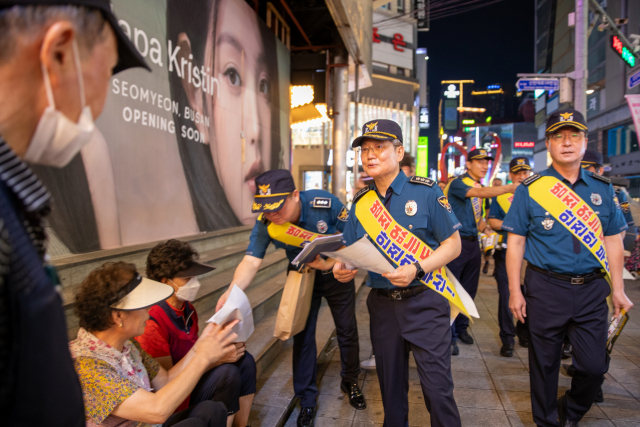 지난 12일 오후 부산 전역에서 진행된 민관경합동순찰에 참여한 우철문(가운데) 부산경찰청장이 도시철도 서면역 인근에서 시민들에게 유인물을 나눠주고 있다. 부산경찰청 제공