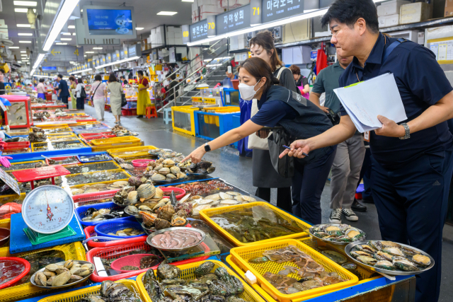 13일 오후 부산 중구 자갈치시장에서 합동점검반이 수입 수산물 원산지 표시 특별점검을 하고 있다. 부산시와 국립수산물품질관리원 등이 참여한 이번 특별점검은 원산지 미표시, 거짓표시, 표시 손상·변경 행위를 중점 점검했다. 정대현 기자 jhyun@