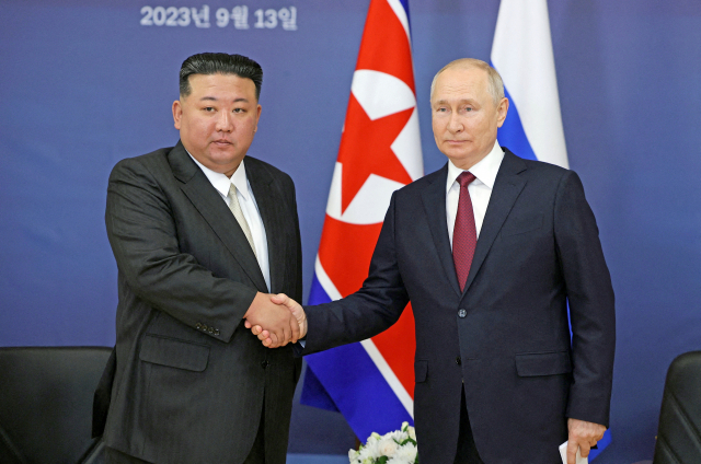 김정은(왼쪽) 북한 국무위원장과 블라디미르 푸틴 러시아 대통령이 13일(현지 시간) 러시아 아무르주 보스토치니 우주기지에서 회담하기에 앞서 악수하고 있다. 두 정상이 회담하는 것은 2019년 4월 이후 4년 5개월 만이다. 스푸트니크 제공