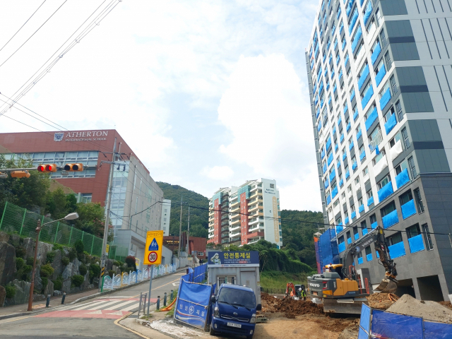 A 건설이 시공 중인 거제시 옥포동 한 아파트 건설 현장. 애서튼국제외국인학교와는 폭 7m 남짓인 왕복 2차선 도로를 사이에 두고 맞닿아 있다. 김민진 기자