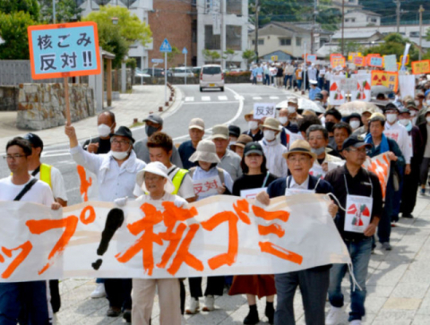 지난 10일 일본 대마도에서 ‘핵 쓰레기 반대’ 등을 쓴 플래카드를 들고 시위 행진하는 참가자들 모습. 서일본신문DB