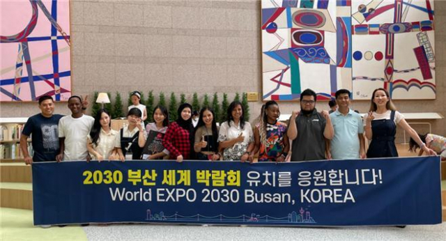 연수에 참가한 연수생들이 부산시청 ‘들락날락’을 방문해 ‘2030 부산 세계박람회’ 유치를 응원하는 현수막을 들고 기념촬영하고 있다. 부산디자인진흥원 제공