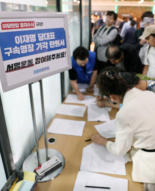 24일 진교훈 더불어민주당 강서구청장 후보자 선거사무소 개소식에서 민주당 지지자들이 이재명 대표 구속영장 기각 탄원서에 서명하고 있다. 연합뉴스 제공.