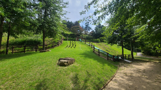 사면 미끄럼틀. 잔디로 된 사면에서 줄을 잡고 올라가 미끄럼틀을 타고 내려오는 놀이 공간으로 아이들이 특히 좋아한다.