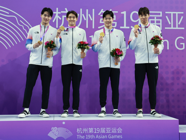 양재훈, 이호준, 김우민, 황선우가 25일 중국 항저우 올림픽 스포츠센터 수영장에서 열린 2022 항저우 아시안게임 수영 남자 800m 계영 결승 시상식에서 금메달을 획득한 뒤 환호하고 있다. 연합뉴스
