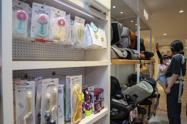 롯데백화점 부산 본점 아동·유아 코너에서 아기를 안은 여성이 아기용품을 살펴보고 있다. 부산일보DB