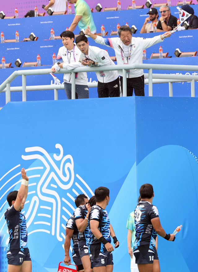 지난 26일 오전 중국 저장성 항저우 사범대에서 열린 2022 항저우 아시안게임 7인제 럭비 준결승전에서 한국 대표팀이 중국을 꺾고 결승 진출을 확정짓자 최윤 대한럭비협회 회장(윗줄 오른쪽)이 태극기를 흔들며 환호하고 있다. 연합뉴스
