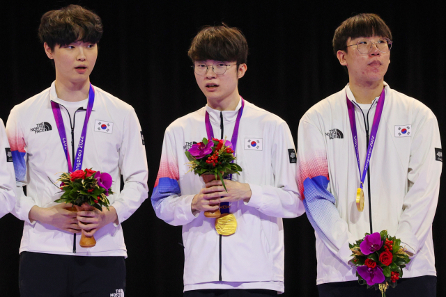 29일 중국 저장성 항저우 e스포츠 센터에서 열린 제19회 항저우 아시안게임 e스포츠 리그 오브 레전드(LoL)에서 금메달을 딴 한국 선수들이 시상대에 올라 있다. 왼쪽부터 '쵸비' 정지훈, '페이커' 이상혁, '룰러' 박재혁. 연합뉴스