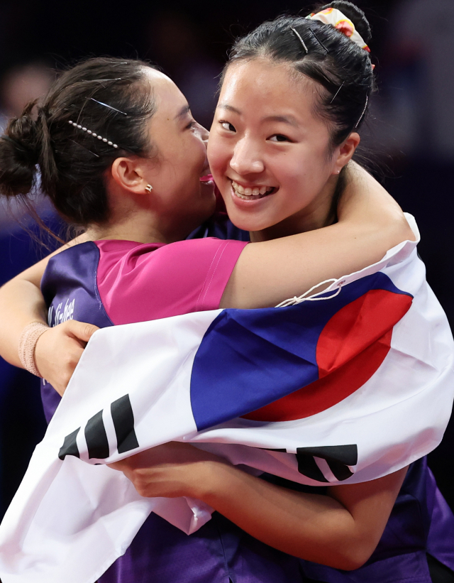 2일 중국 항저우 궁수 캐널 스포츠파크 체육관에서 열린 19회 항저우 아시안게임 탁구 여자 복식 결승전에서 한국 신유빈-전지희가 북한 차수영-박수경에 승리, 금메달을 차지한 후 태극기를 들고 환호하고 있다. 연합뉴스