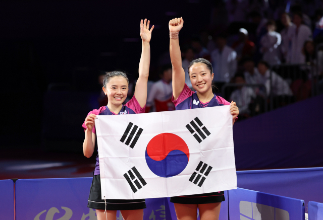 2일 중국 항저우 궁수 캐널 스포츠파크 체육관에서 열린 19회 항저우 아시안게임 탁구 여자 복식 결승전에서 한국 신유빈-전지희가 북한 차수영-박수경에 승리, 금메달을 차지한 후 태극기를 들고 환호하고 있다. 연합뉴스