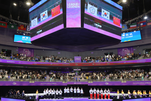 지난달 29일 중국 저장성 항저우 e스포츠 센터에서 열린 제19회 항저우 아시안게임 e스포츠 '리그 오브 레전드(LoL)'에서 금메달을 딴 한국 '제우스' 최우제, '카나비' 서진혁, '쵸비' 정지훈, '페이커' 이상혁, '룰러' 박재혁, '케리아' 류민석이 시상대에 올라 국기에 경례하고 있다. 연합뉴스