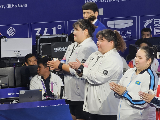 부산광역시체육회 소속 여자 역도 +87kg급 국가대표인 손영희(가운데)와 박혜정(손영희 왼쪽)이 7일 중국 항저우 샤오산 스포츠센터 체육관에서 열린 2022 항저우 아시안게임 역도 여자 +87kg급 경기 시작에 앞서 관중들에게 인사하고 있다. 항저우=김한수 기자 hangang@