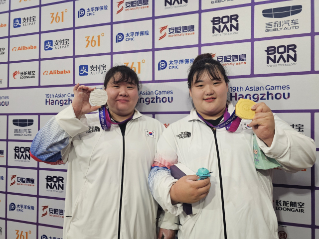 한국 역도 여자 최중량급 국가대표 선수인 손영희(30·부산광역시체육회·왼쪽)와 박혜정(20·고양시청)이 7일 2022 항저우 아시안게임 역도 여자 87kg 이상급 경기 공식기자회견에서 각각 은메달과 금메달을 들고 포즈를 취하고 있다. 항저우=김한수 기자 hangang@