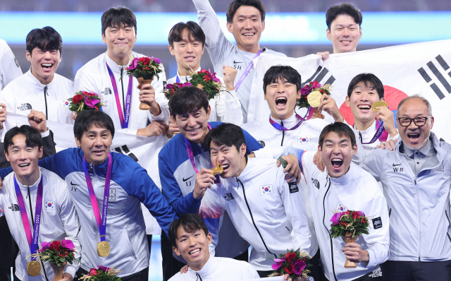 2022 항저우 아시안게임 남자 축구에서 대회 3연패를 달성한 한국 축구 대표팀 선수단이 7일 중국 항저우 황룽 스포츠센터 스타디움에서 열린 시상식에서 금메달을 목에 걸고 기념촬영을 하고 있다. 메달을 깨물어 보는 이강인이 눈길을 사로잡는다. 연합뉴스