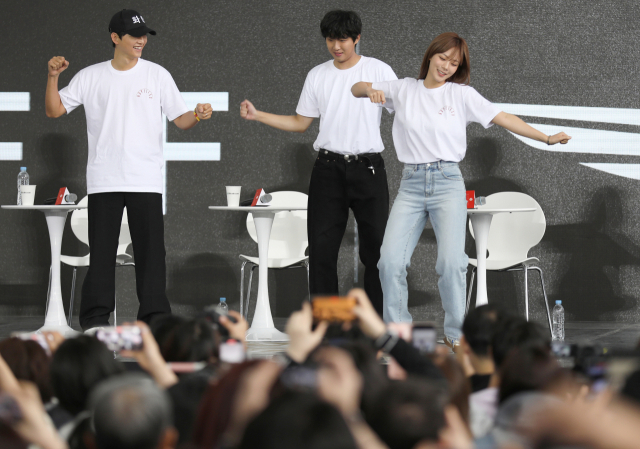 영화의전당 야외무대에서 열린 부산국제영화제(BIFF) 오픈 토크에 참석한 영화 ‘화란’ 팀. 배우 송중기(왼쪽), 홍사빈(가운데), 김형서(오른쪽)가 뉴진스 ‘Hype Boy’ 춤을 추고 있다. 안지현 인턴기자