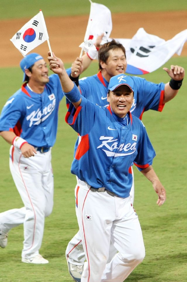 2008년 베이징올림픽 야구 결승전 쿠바와의 경기에서 승리해 금메달을 딴 한국 선수들이 태극기를 들고 그라운드를 돌고 있다. 이승엽(맨 앞)과 이대호도 주전으로 참여해 금메달 수확에 큰 힘을 보탰다. 연합뉴스