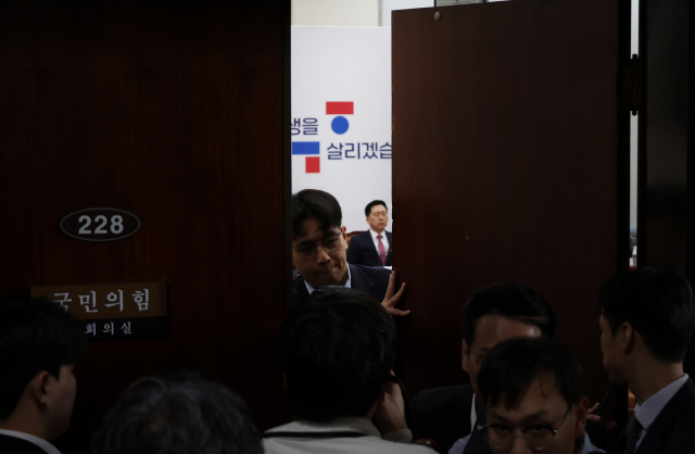 국민의힘 김기현 대표가 12일 국회에서 열린 당 최고위원회의에서 어두운 표정을 짓고 있다. 회의가 비공개로 전환되자 당 관계자가 출입문을 닫고 있다. 연합뉴스