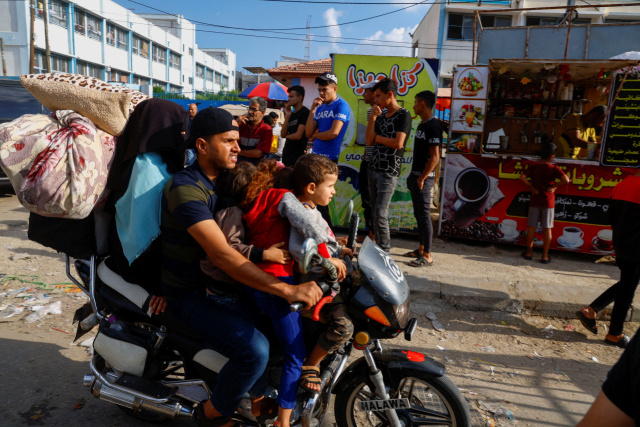 16일(현지 시간) 가자지구 남부의 칸 유니스에서 팔레스타인 가족이 오토바이를 타고 이주하고 있다. 이스라엘은 가자지구 지상작전을 예고하며 주민들에게 대피명령을 내렸다. 로이터연합뉴스