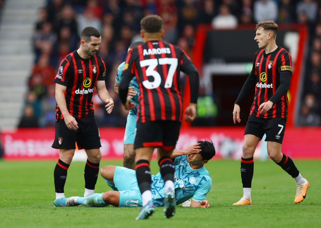 울버햄프턴의 황희찬(가운데)이 22일(한국시간) 영국 본머스의 바이탈리티 스타디움에서 열린 2023-2024 잉글랜드 프로축구 프리미어리그(EPL) 본머스와의 원정 경기에서 본머스의 루이스 쿡이 머리로 얼굴을 들이받자 쓰러져 고통을 호소하고 있다. 쿡은 곧바로 퇴장당했다. 로이터연합뉴스