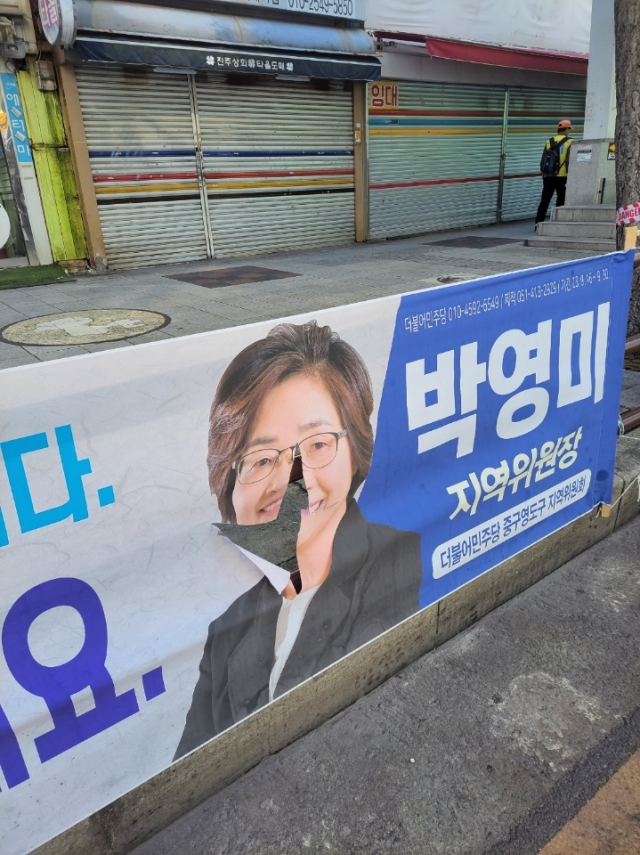 부산 중부경찰서가 정당 현수막을 훼손한 혐의로 70대 남성 A 씨를 불구속 송치했다. 사진은 더불어민주당 부산시당 정당 현수막이 훼손된 모습. 더불어민주당 부산시당 제공