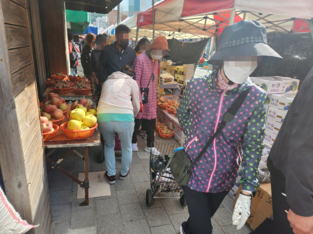 22일 경남 창원시 의창구 소답동 오일장에서 인도에 깔린 좌판으로 인해 시민들이 통행에 불편을 겪고 있다. 강대한 기자