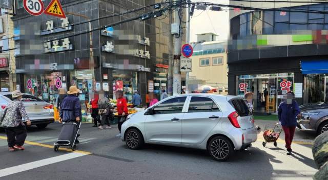22일 경남 창원시 의창구 소답시장 앞 차로에 승용차와 시민이 뒤엉켜 있다. 강대한 기자