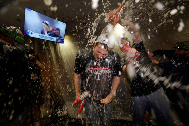 24일(한국시간) 미국 텍사스주 휴스턴의 미닛메이드파크에서 열린 2023 미국 프로야구 메이저리그 아메리칸리그 챔피언십시리즈(ALCS) 7차전에서 휴스턴 애스트로스를 물리치고 월드시리즈에 진출한 텍사스 레인저스 선수들이 로커룸에서 샴페인을 터트리며 자축하고 있다. AFP연합뉴스