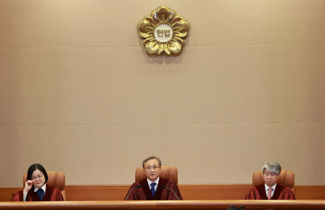 유남석 헌법재판소장(가운데)이 26일 서울 종로구 헌법재판소 대심판정에서 열린 위헌 제청 및 권한쟁의 심판 선고를 시작하고 있다. 연합뉴스
