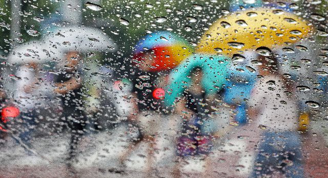 시민들이 부산 남구의 한 건널목에서 우산을 쓰고 발걸음을 재촉하고 있는 모습. 기상청이 오는 16일 수능 날 새벽부터 아침 사이에는 대체로 흐리다가 오후부터는 비가 올 것으로 예보했다. 김종진 기자 kjj1761@