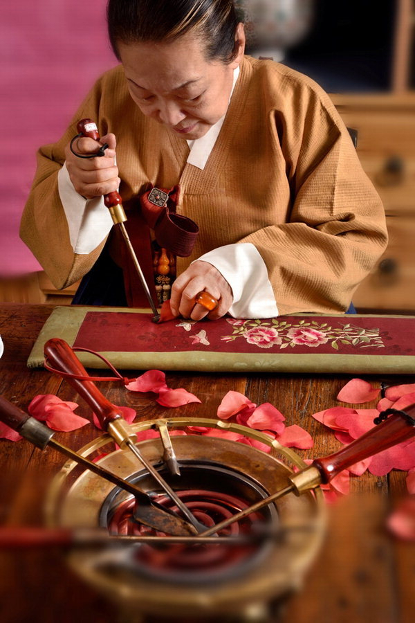 궁중채화장 황수로 박사가 인두로 꽃 모양을 잡고 있는 모습. 한국궁중꽃박물관 제공