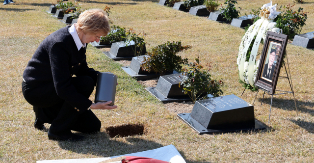 15일 부산 남구 유엔기념공원 참전용사묘역에서 열린 벨기에 한국전쟁 참전용사 레옹 보스케 씨의 유해 안장식에서 딸 다니엘 보스케 씨가 아버지의 유해를 안장하고 있다. 정종회 기자 jjh@