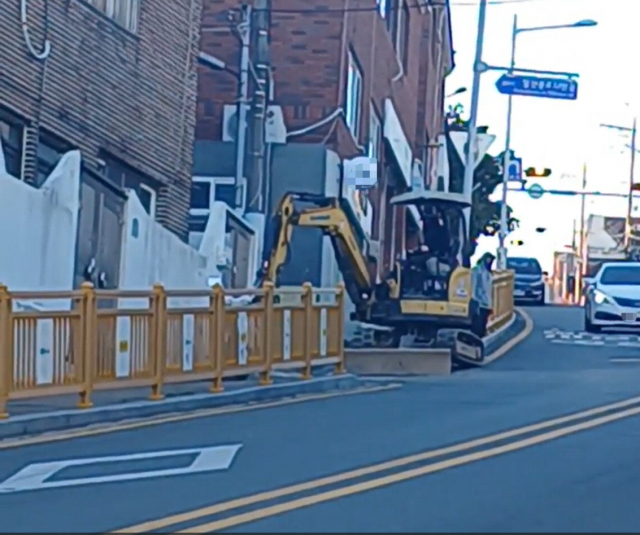 부산 영도구 청동초등 등굣길에서 굴착기가 도로를 점용한 채 공사하는 모습. 청동초등 학부모회 제공
