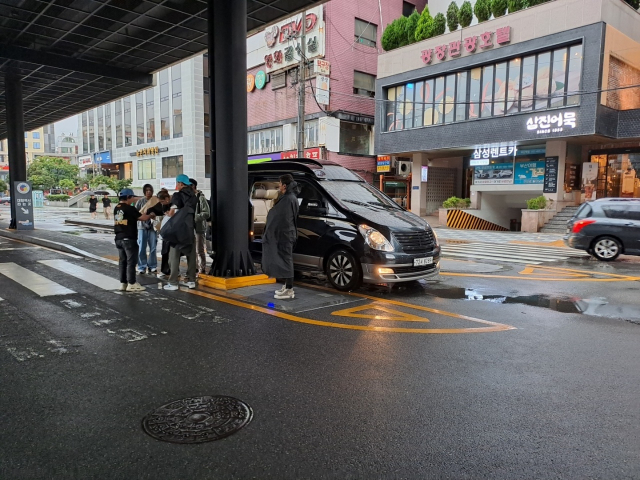 부산 동부경찰서는 등록되지 않은 자동차를 활용해 관광객을 태우고 일반 택시보다 3~4배 요금을 받은 혐의로 불법 렌터카 10대를 특정해 업자 등을 수사 중이다. 사진은 불법 렌터카 업자가 손님을 태우려는 모습. 부산개인택시운송조합 제공