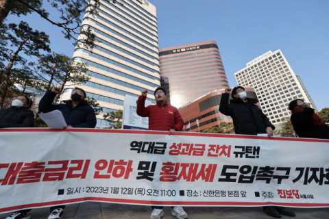 지난해에 이어 올해도 은행들의 이자 이익이 역대 최대 규모에 이를 것으로 전망되면서 횡재세 논란이 뜨겁다. 올해 초 한 은행 앞에서 있었던 대출금리 인하와 횡재세 도입을 촉구하는 기자회견 장면. 연합뉴스