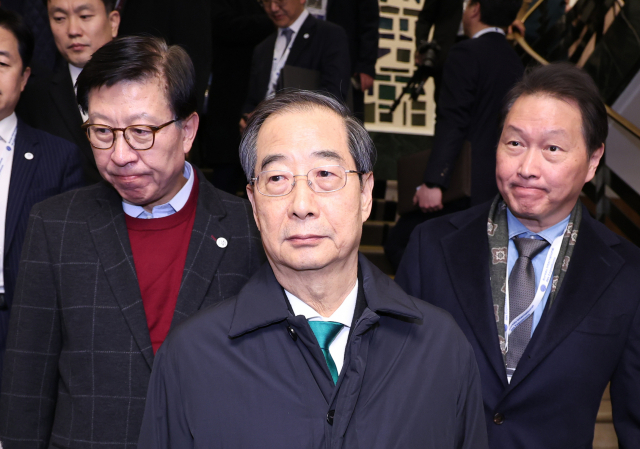 한덕수 국무총리가 28일 오후(현지시간) 프랑스 파리 교외 도시 이시레물리노의 전시 시설 ‘팔레 드 콩그레’에서 열린 제173차 국제박람회기구(BIE) 총회에서 2030년 세계박람회 개최지 투표 결과 부산이 탈락한 뒤 기자회견을 위해 이동하고 있다. 왼쪽부터 박형준 부산시장, 한 총리, 최태원 대한상의 회장. 연합뉴스