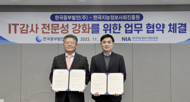 한국중부발전(주) 곽영교 상임감사위원(왼쪽)과 한국지능정보사회진흥원 정연택 감사가 협약 체결 후 기념촬영을 하고 있다. 중부발전 제공