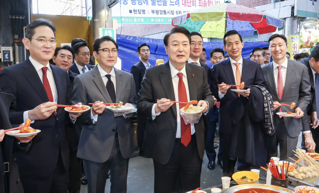 윤석열 대통령이 6일 부산 중구 깡통시장을 방문해 재계 총수들과 함께 분식을 맛보고 있다. 앞줄 왼쪽부터 이재용 삼성전자 회장, 조현준 효성그룹 회장, 윤 대통령, 구광모 LG그룹 회장, 김동관 한화그룹 부회장, 정기선 HD현대 부회장. 김종진 기자 kjj1761@