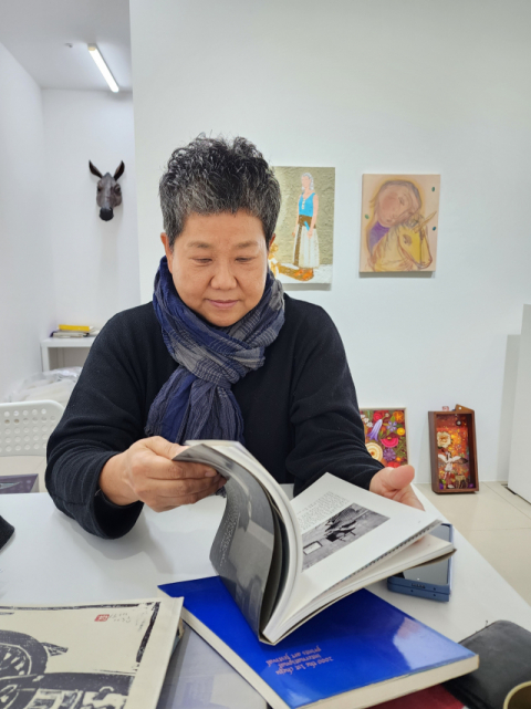 김이선 큐레이터가 신동문화사에서 만든 책자를 들여다 보고 있다.