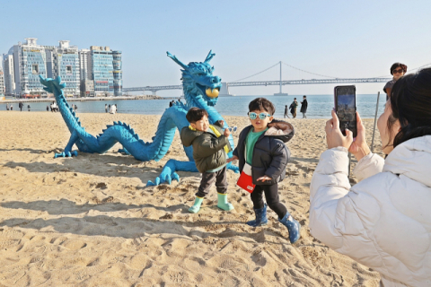 부산 광안리해수욕장에 설치된 청룡 조형물 앞에서 시민들이 기념사진을 찍고 있다. 부산일보 DB